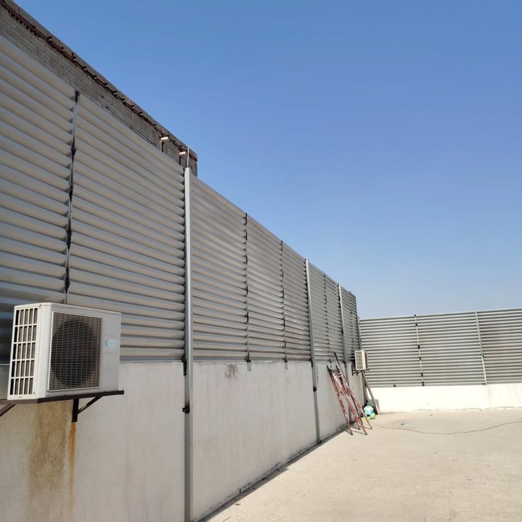 تركيب ساتر حديد شرائح لوفر باللون البيج الفاتح على جدار سطح منزل من ساترون لمقاومة الرياح والخصوصية